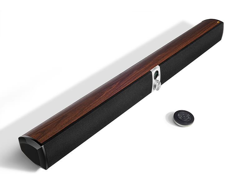 A remote control is placed before a soundbar.